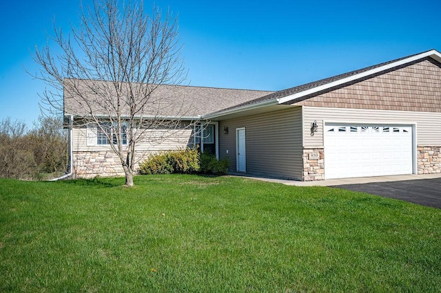 single story home featuring a garage, driveway, a front yard, and stone siding