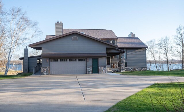 35873 Drumbeater Rd, Cohasset, MN 55721 - view of front of home with a chimney, concrete driveway, a water view, and a front lawn