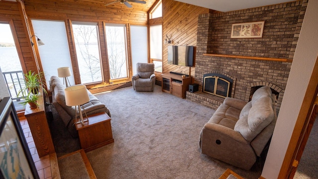 35873 Drumbeater Rd, Cohasset, MN 55721 - carpeted living area featuring a baseboard radiator, ceiling fan, wooden walls, healthy amount of natural light, and a brick fireplace