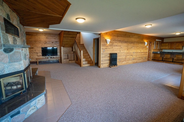 35873 Drumbeater Rd, Cohasset, MN 55721 - unfurnished living room with wood walls, stairs, carpet flooring, and a wood stove