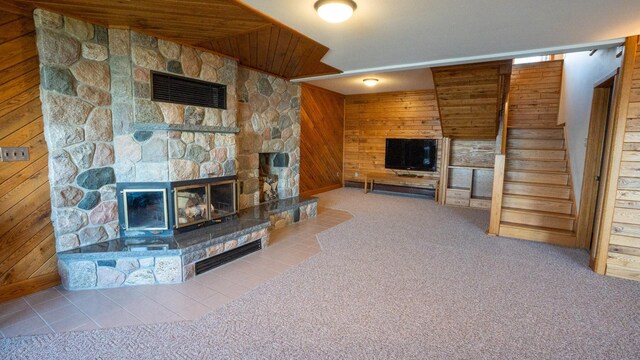 35873 Drumbeater Rd, Cohasset, MN 55721 - unfurnished living room featuring wood walls, a fireplace, stairway, carpet floors, and tile patterned flooring