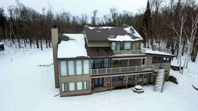 35873 Drumbeater Rd, Cohasset, MN 55721 - snow covered back of property featuring a balcony and a chimney