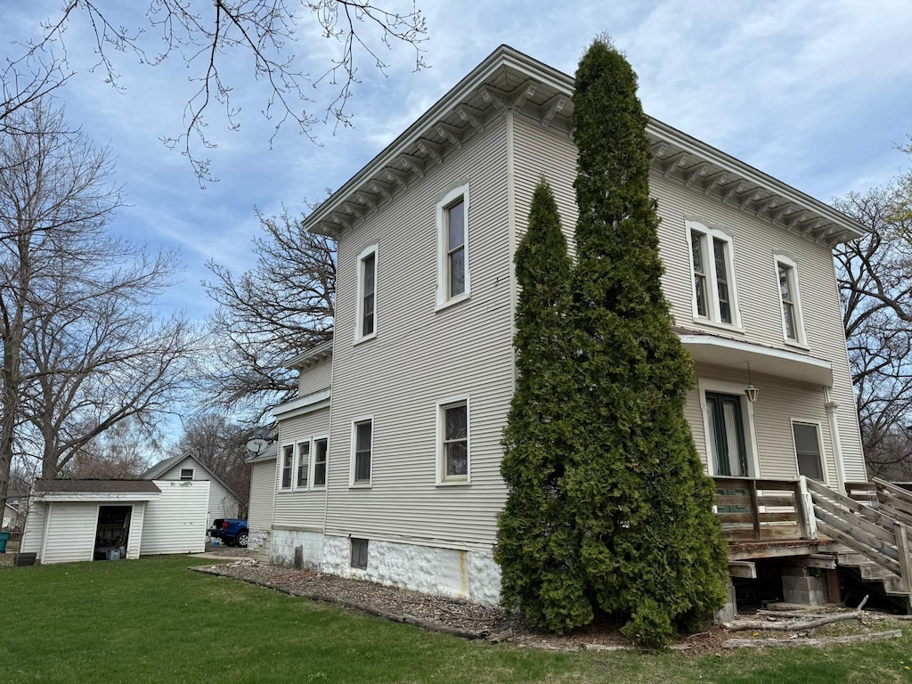 view of property exterior with a lawn and an outdoor structure