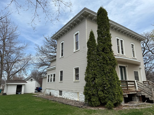 view of property exterior with a lawn and an outdoor structure