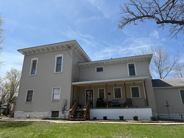back of property with a porch and a lawn