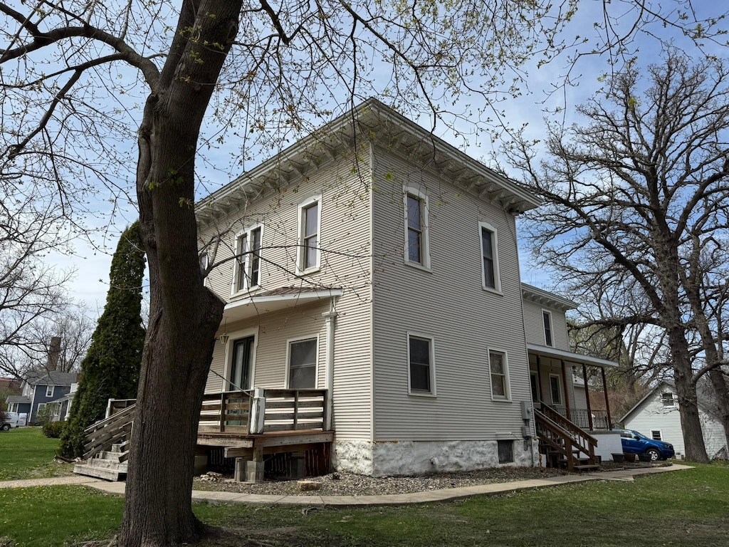 view of side of property featuring a lawn and a wooden deck