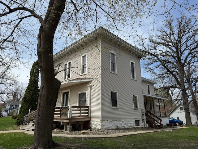 view of side of property featuring a lawn and a wooden deck