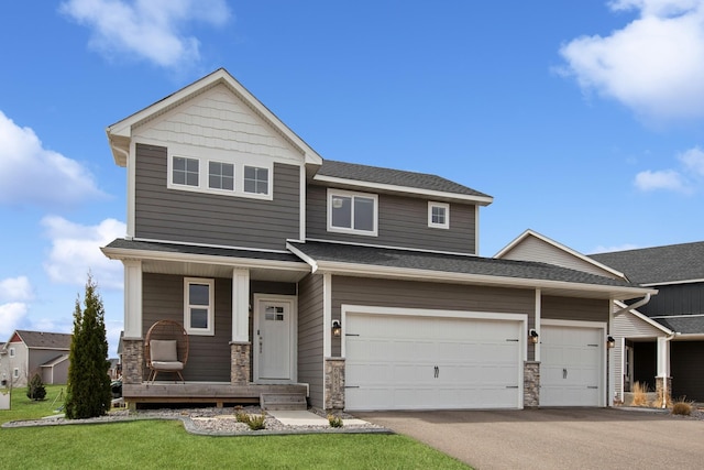 view of front facade featuring a shingled roof, aphalt driveway, covered porch, and stone siding