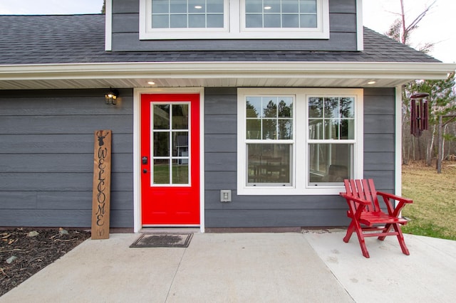 property entrance featuring roof with shingles