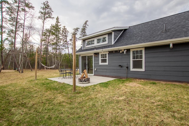 back of house with a patio, a shingled roof, a fire pit, and a lawn