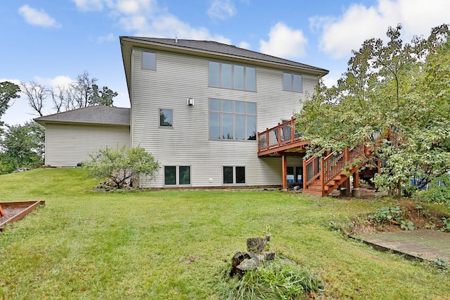 rear view of property featuring a lawn, a wooden deck, and stairs