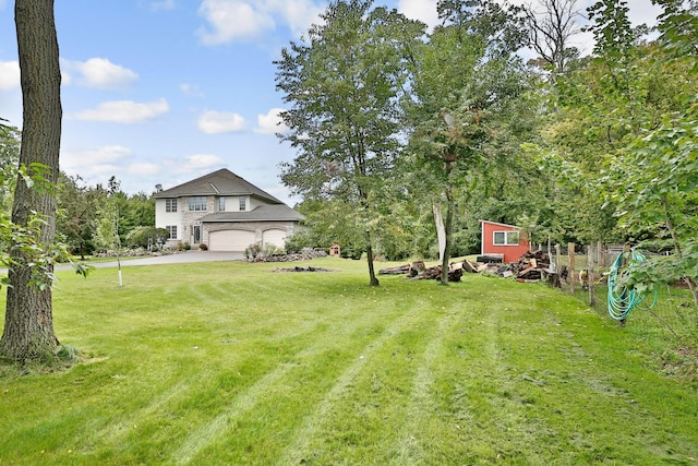 view of yard featuring an attached garage and driveway