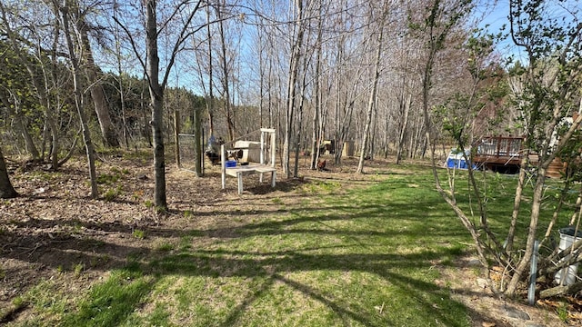 view of yard featuring a deck and a wooded view