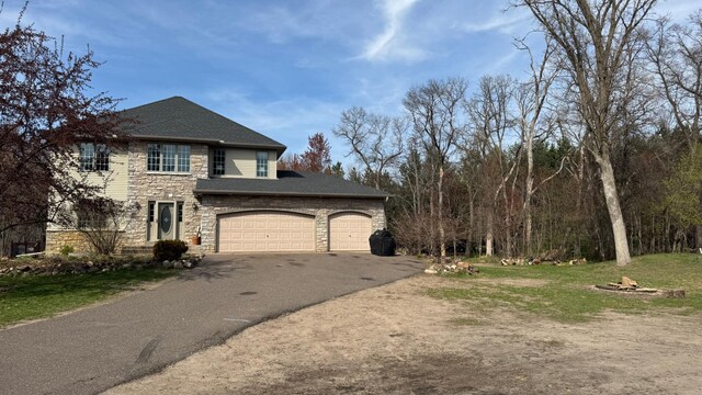 view of home's exterior with an attached garage, driveway, and stone siding