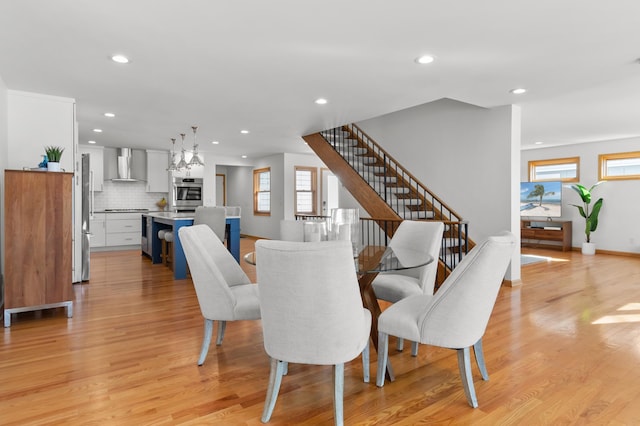 dining area with recessed lighting, light wood-type flooring, stairs, and baseboards