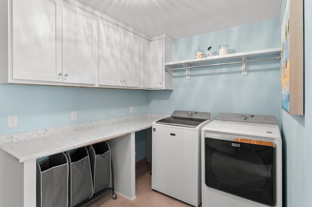 laundry room with washing machine and dryer, cabinet space, and light tile patterned flooring