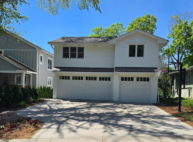 view of front of home featuring an attached garage, a standing seam roof, concrete driveway, metal roof, and a shingled roof