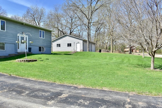 view of yard with a garage and an outbuilding