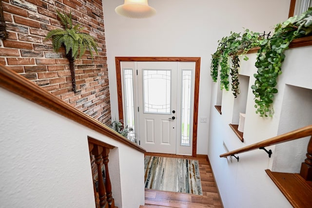 entrance foyer featuring baseboards, wood finished floors, and stairway