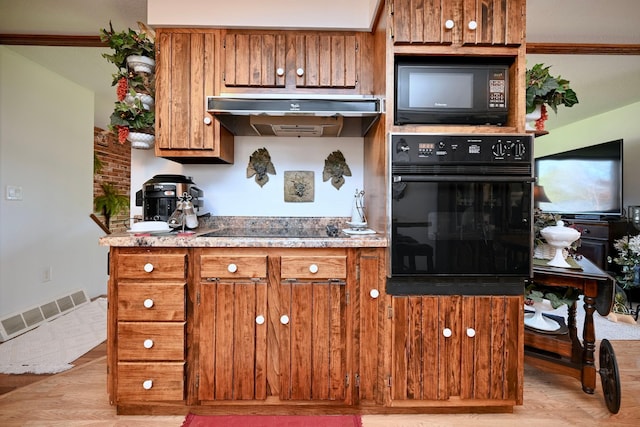 kitchen featuring brown cabinetry, visible vents, black appliances, under cabinet range hood, and light wood-style flooring