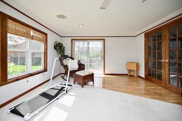sitting room with baseboards, ornamental molding, french doors, and wood finished floors