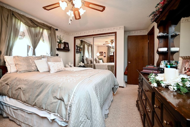 bedroom featuring ceiling fan, a closet, and light colored carpet
