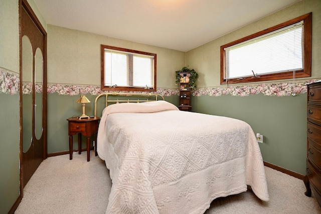 bedroom featuring baseboards and light carpet
