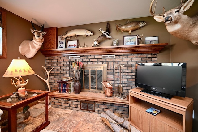 living area featuring stone finish floor and visible vents
