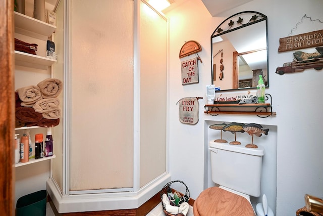 full bathroom featuring toilet and a stall shower
