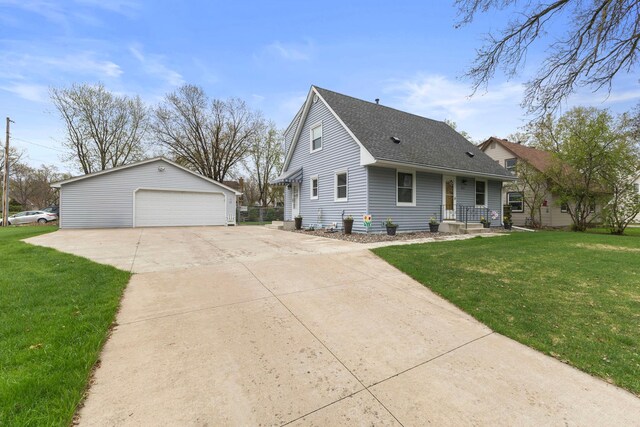10851 Olive St NW, Coon Rapids, MN 55448 - view of front of house featuring a garage, an outbuilding, a front yard, and roof with shingles