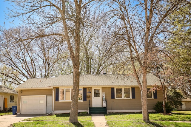 single story home with a garage, a front yard, and concrete driveway