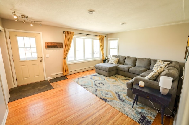 living room featuring baseboards, plenty of natural light, baseboard heating, and wood finished floors