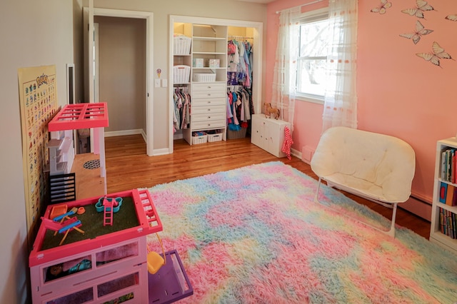 playroom featuring baseboards and wood finished floors