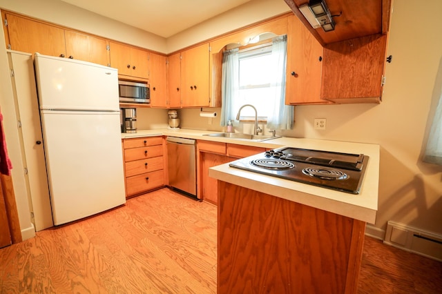 kitchen featuring appliances with stainless steel finishes, a sink, light wood finished floors, light countertops, and visible vents