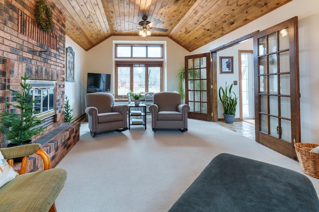 living area with lofted ceiling, a fireplace, ceiling fan, wooden ceiling, and carpet