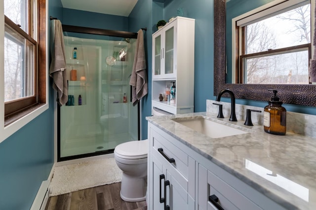 full bath with a stall shower, wood finished floors, and a wealth of natural light