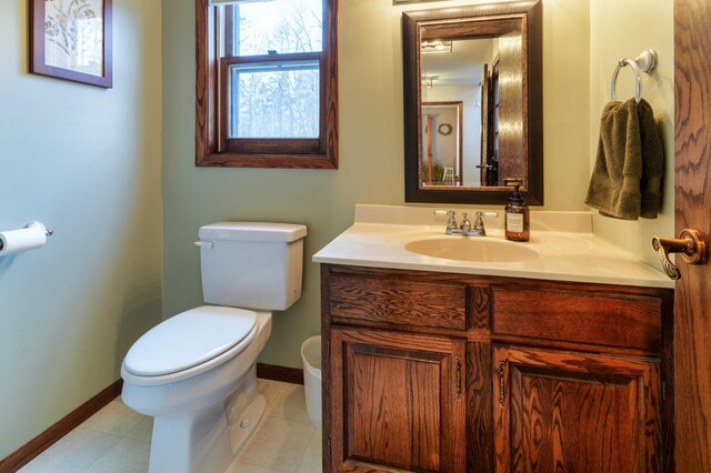 bathroom featuring baseboards, vanity, and toilet