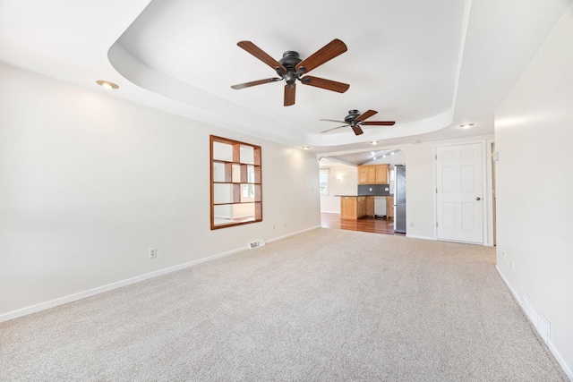 19797 612th Ave, Litchfield, MN 55355 - unfurnished living room featuring a raised ceiling, a ceiling fan, carpet flooring, baseboards, and recessed lighting