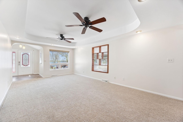 19797 612th Ave, Litchfield, MN 55355 - unfurnished living room featuring a tray ceiling, light colored carpet, baseboards, and a ceiling fan