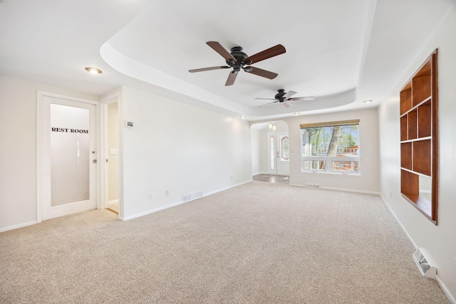 19797 612th Ave, Litchfield, MN 55355 - spare room with a raised ceiling, light carpet, a ceiling fan, arched walkways, and baseboards