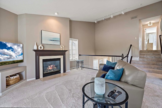 carpeted living room with rail lighting, baseboards, and a fireplace