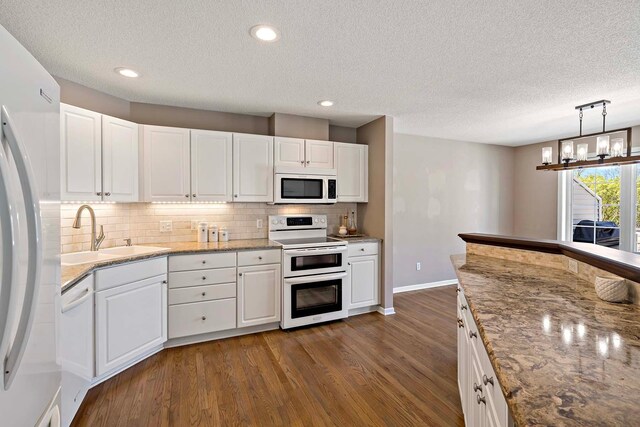 kitchen featuring white appliances, a sink, baseboards, dark wood-type flooring, and decorative backsplash