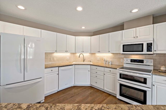 kitchen featuring white appliances, a sink, wood finished floors, white cabinetry, and a textured ceiling