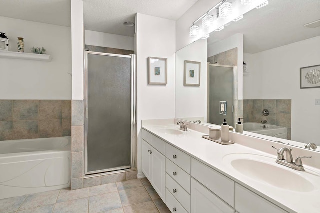 full bathroom with a stall shower, a garden tub, tile patterned floors, double vanity, and a textured ceiling
