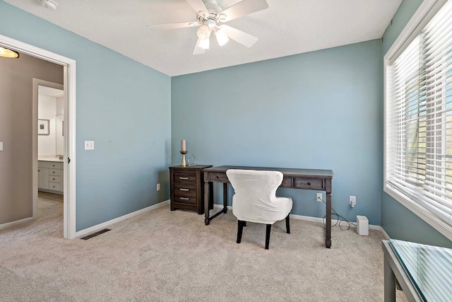 carpeted office featuring a ceiling fan and baseboards