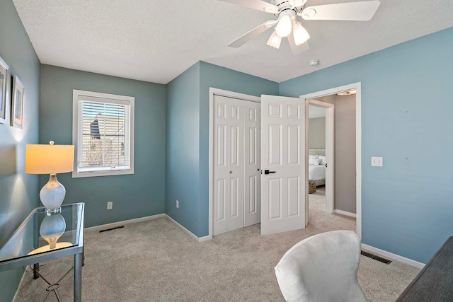 office with carpet floors, a ceiling fan, baseboards, and a textured ceiling