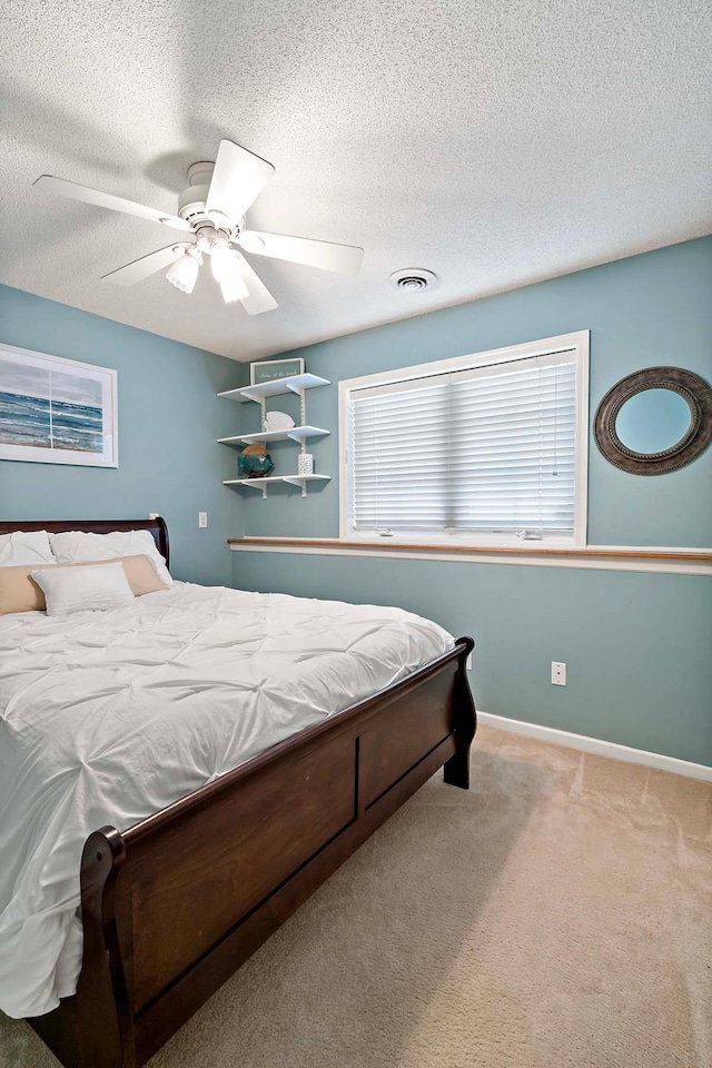 bedroom featuring carpet floors, ceiling fan, a textured ceiling, and baseboards