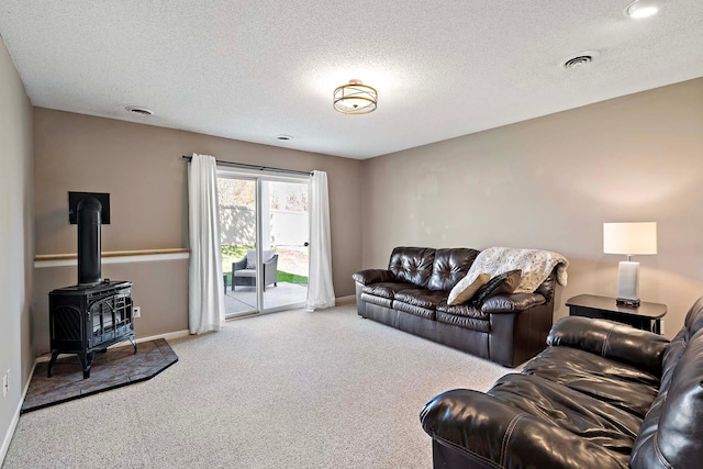 carpeted living room with baseboards, a textured ceiling, and a wood stove