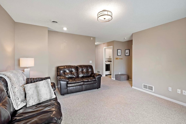 carpeted living room with baseboards and a textured ceiling