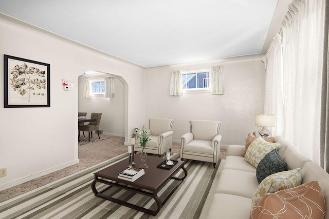 living room with carpet, arched walkways, and baseboards